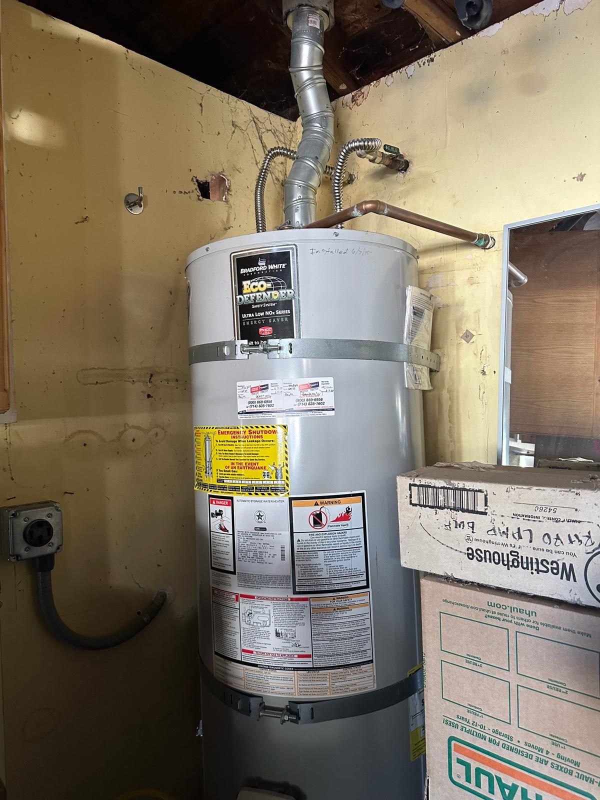 Gas water heater with earthquake straps and a flexible gas connector in a garage corner